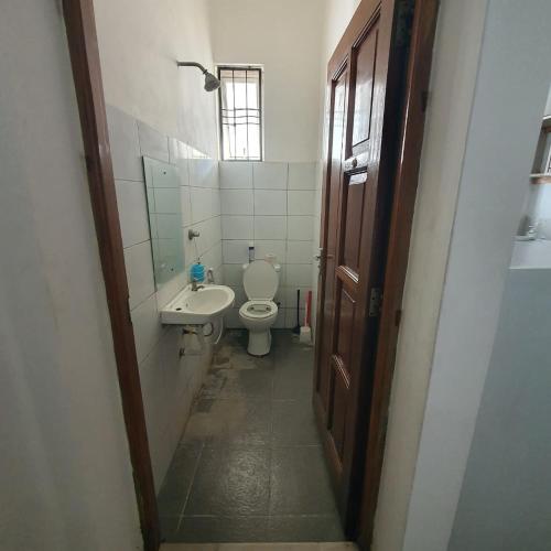 a small bathroom with a toilet and a sink at Cosy 1bedroom hideout within Mombasa CBD in Mombasa