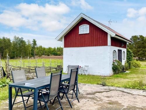 a table and chairs in front of a red and white barn at 3 person holiday home in Berga-By Traum in Berga