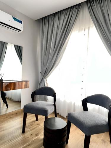 a living room with two chairs and a tv at Lush Cove Apartments in Lekki