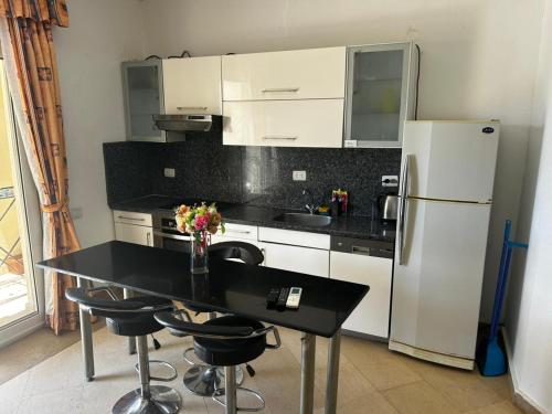 a kitchen with a black table and a refrigerator at apartment on the beach inside a hotel in Sharm El Sheikh