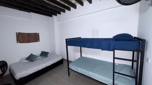 a bedroom with two bunk beds in a room at Hostal Pueblito Samario in Santa Marta