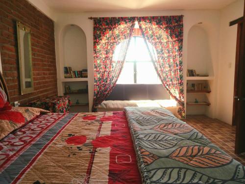 a bedroom with a large bed in front of a window at El Bello Jardín de Chela in Guanajuato