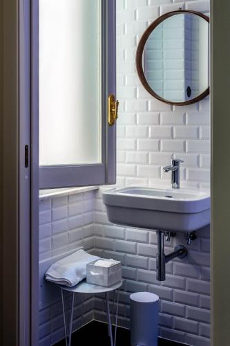 a white bathroom with a sink and a mirror at Al Sale in Cagliari