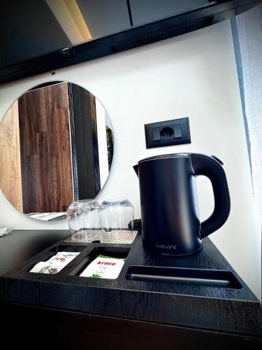 a coffee pot sitting on a counter in front of a mirror at Martin Luxury Hotel in Gjirokastër