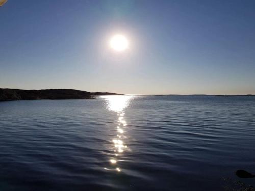 a sun setting over a large body of water at Seaside Serenity in Mollosund-By Traum in Mollösund