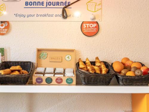 a shelf with baskets of fruits and vegetables on it at ibis budget Le Puy En Velay in Le Puy en Velay