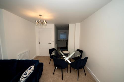 a dining room with a glass table and chairs at Chapel Waters Sleeps 6 with Private Parking in Lower Bradway