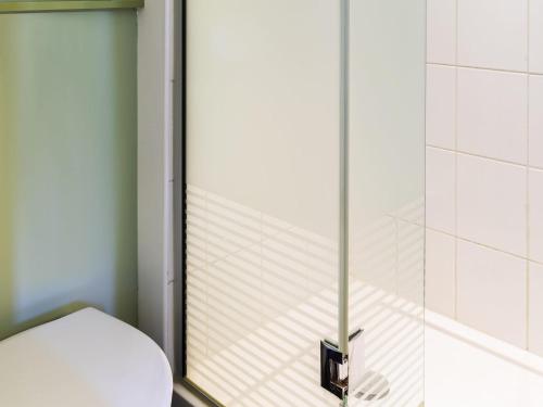 a bathroom with a toilet and a shower at Ibis Budget St Gratien - Enghien-Les-Bains in Saint-Gratien