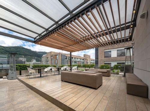 a patio with couches and chairs on a building at Hotel Chico 97 By OxoHotel in Bogotá