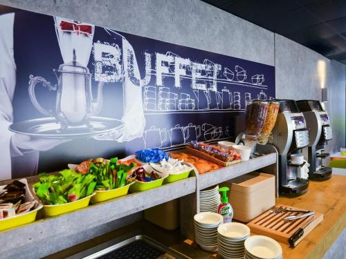 a kitchen with a counter with dishes of food at ibis budget Toulouse Colomiers in Colomiers