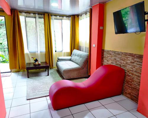 a living room with a red couch and a tv at Kenai Mountain View in Concepción