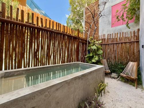 a swimming pool in front of a wooden fence at The Heart of the City Room 3 in Mérida