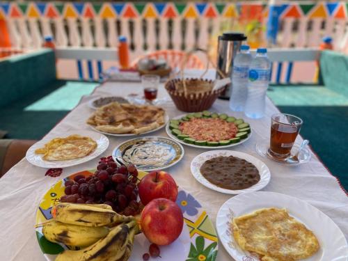 a table topped with plates of food and fruit at Reagan House in Aswan