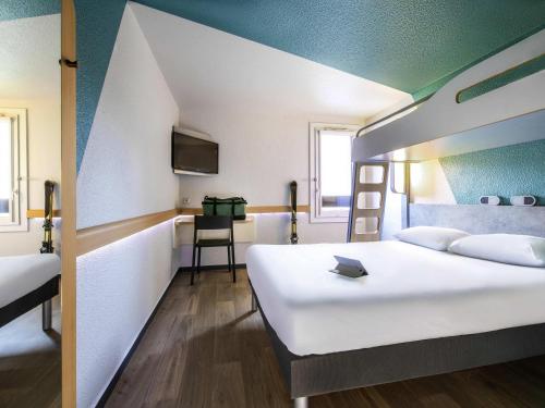 a room with two beds and a bunk bed at ibis budget Grenoble Voreppe in Voreppe