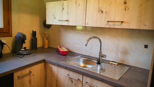 a kitchen sink with a faucet on a counter at La casa del jardì - Jardin clos, WIFI, authentique in Angoustrine