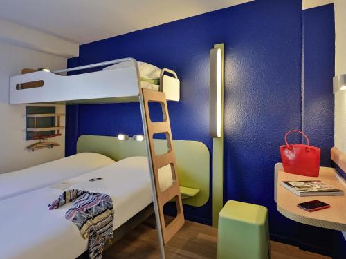 a bedroom with a bunk bed with a ladder and a desk at Ibis budget Chambéry Centre Ville in Chambéry