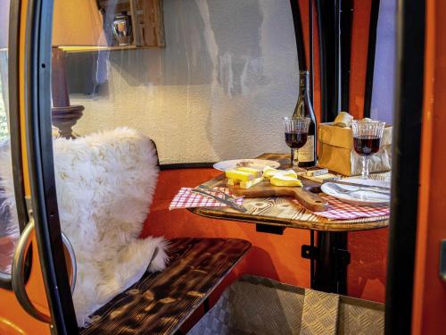 a table with two glasses of red wine and a chair at greet hôtel Annecy Cran-Gevrier by Accor in Annecy
