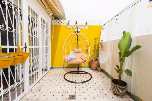 een kamer met een schommel en een gele muur bij Casa JOY in Casablanca