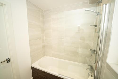 a white bathroom with a tub and a shower at Chapel Waters Sleeps 6 with Private Parking in Lower Bradway