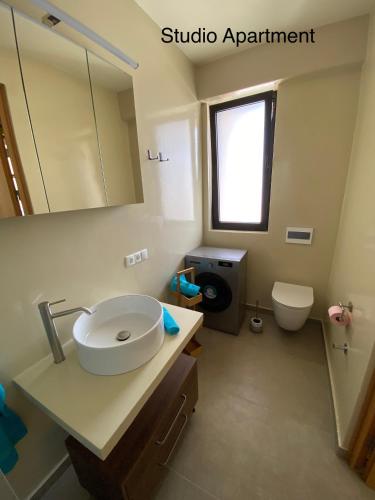a bathroom with a sink and a mirror and a toilet at Crown Paradise Beach Lagoon Studio in Sal Rei