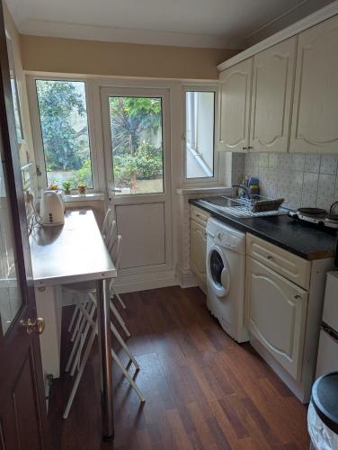 a kitchen with a washing machine and a sink at 8A Kenilworth Road in Portsmouth