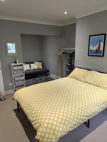 a bedroom with a bed with a yellow bedspread at 8A Kenilworth Road in Portsmouth