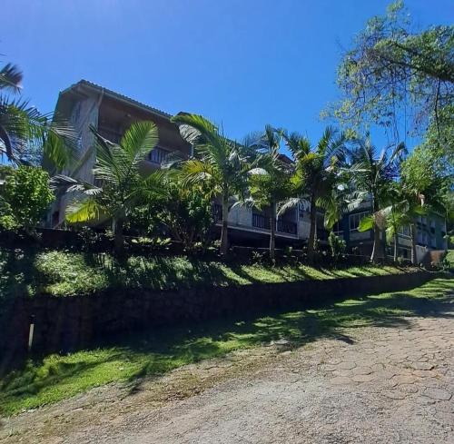 a house on the side of a road with palm trees at Pousada Dona Francisca in Florianópolis