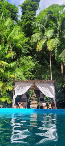 a view of a swimming pool with a tent and trees at Pousada Dona Francisca in Florianópolis