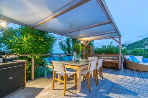 a deck with a table and chairs and a grill at Ti'Cactus 1-bedroom apartment with private pool in Saint-Jean