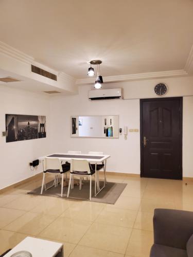 a room with a table and chairs and a black door at كوزمو in Umm Uthainah