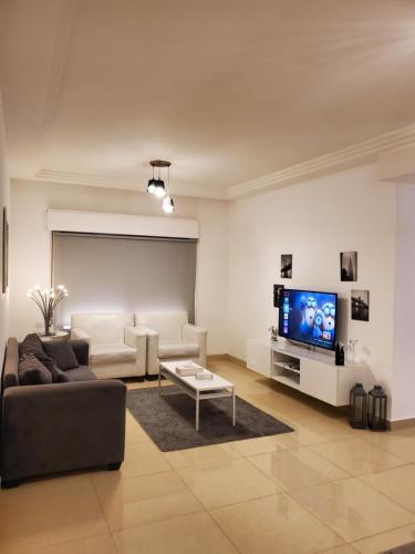 a living room with a couch and a tv at كوزمو in Umm Uthainah