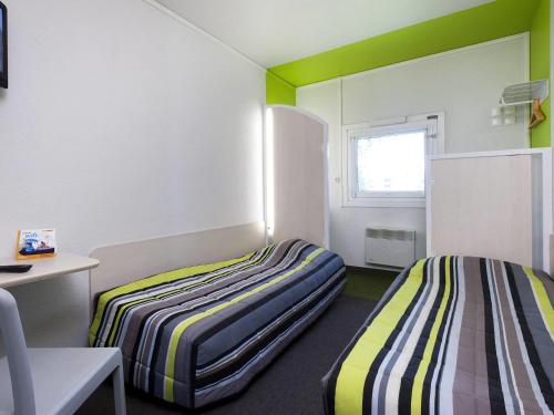 two beds in a room with green and white at hotelF1 Aix En Provence Sainte Victoire in Meyreuil
