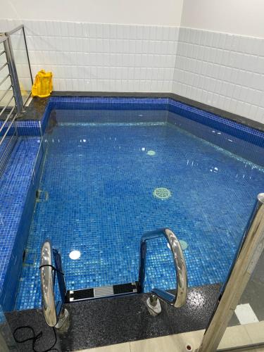 a swimming pool with blue tiles on the floor at Al Samo Apartment in Ḩayl Āl ‘Umayr