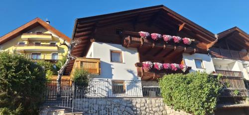 a house with flowers on the balconies of it at Apartments Insam in Santa Cristina in Val Gardena