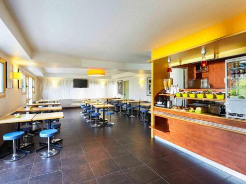 a large room with tables and chairs in a restaurant at ibis budget Chartres in Chartres