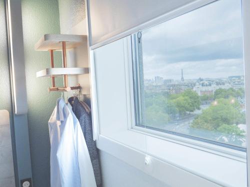 a window in a room with a view of a city at ibis budget Porte D'Orleans in Paris