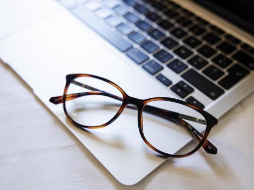 a pair of glasses sitting on a laptop computer at ibis budget Porte D'Orleans in Paris