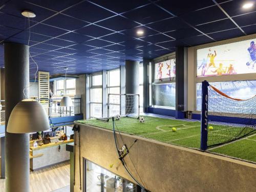 a large room with a soccer field on the wall at ibis budget Porte D'Orleans in Paris