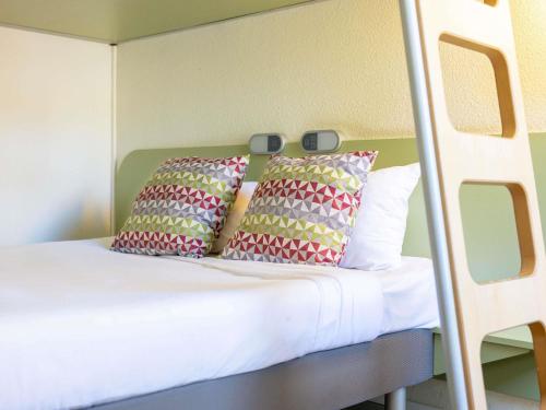 a bed with two pillows on top of it at ibis budget Narbonne Sud A9/A61 in Narbonne