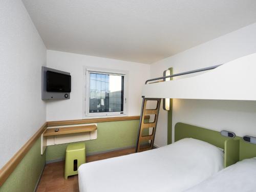a room with two bunk beds and a tv at ibis budget Nice Aeroport in Nice