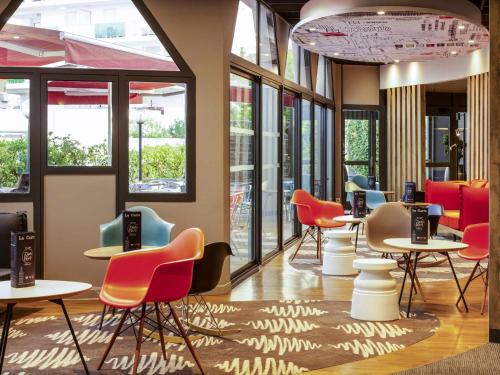 a waiting room with colorful chairs and tables at ibis budget Montpellier Sud Près d'Arènes in Montpellier