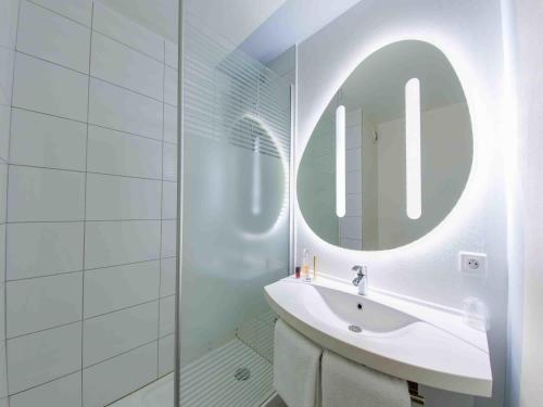 a white bathroom with a sink and a mirror at ibis budget Montpellier Sud Près d'Arènes in Montpellier