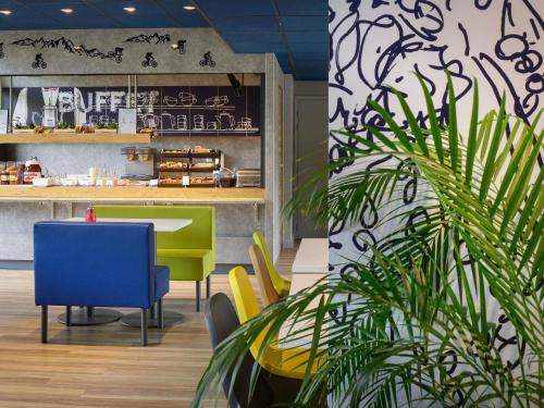a restaurant with a table and chairs and a plant at ibis budget Toulouse Centre Gare in Toulouse