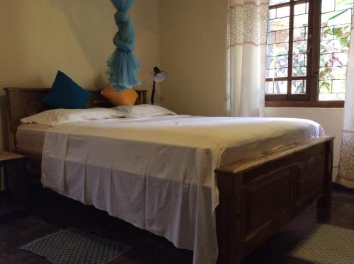 a bedroom with a large bed with a blue headboard at Mount Haven in Kandy