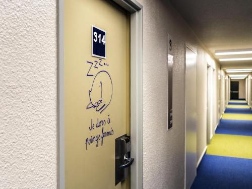 a hallway with a door with a clock on it at ibis budget Paris Porte de Bercy in Charenton-le-Pont