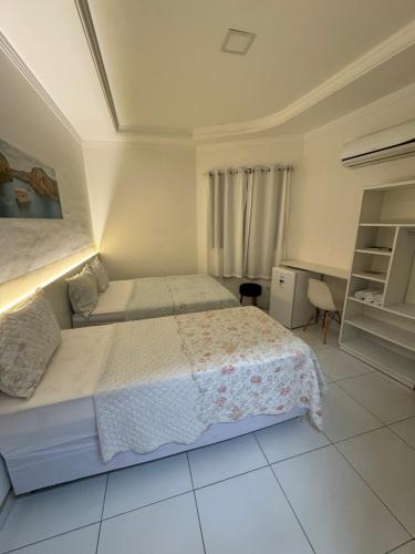 a bedroom with a large bed and a white floor at Hotel Mandacaru in Piranhas