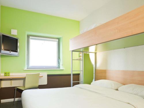 Una cama o camas en una habitación de ibis budget Nancy Porte Sud