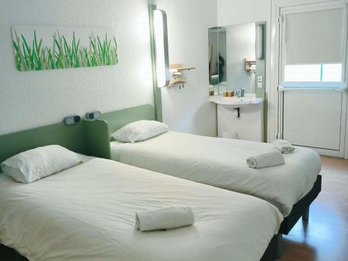 two beds in a room with a sink at ibis budget Poitiers Nord Futuroscope in Chasseneuil-du-Poitou