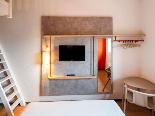 Una televisión o centro de entretenimiento en ibis budget Nancy Porte Sud