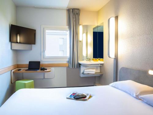 a hotel room with a bed and a sink at ibis budget Paris Porte De Montmartre in Paris